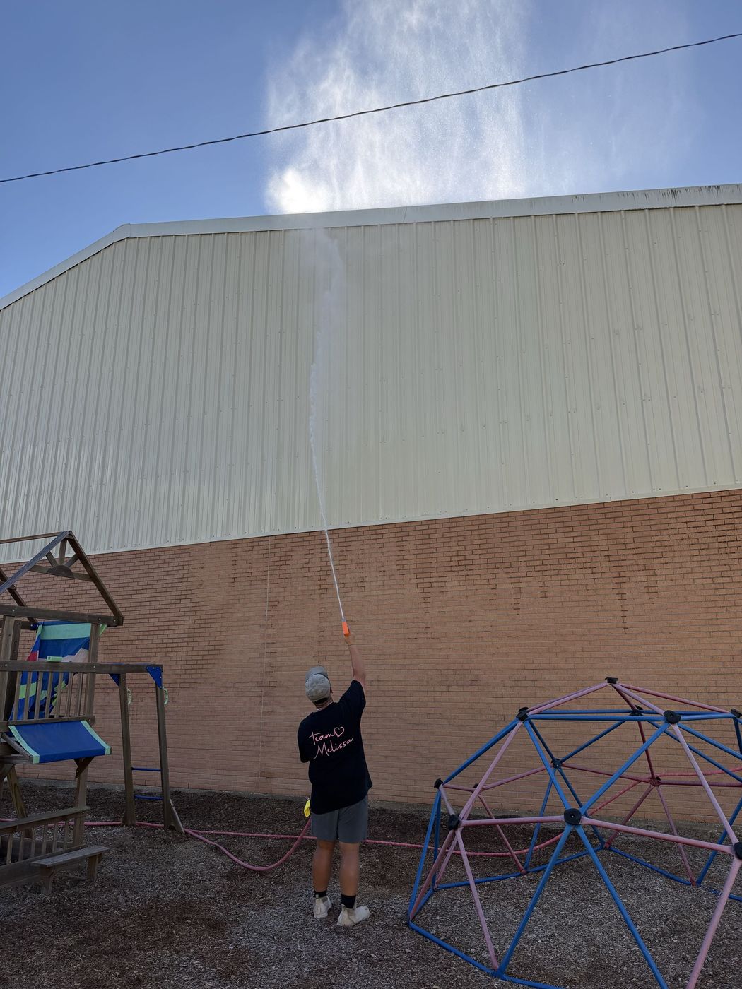 Soft washing a brick and metal exterior wall
